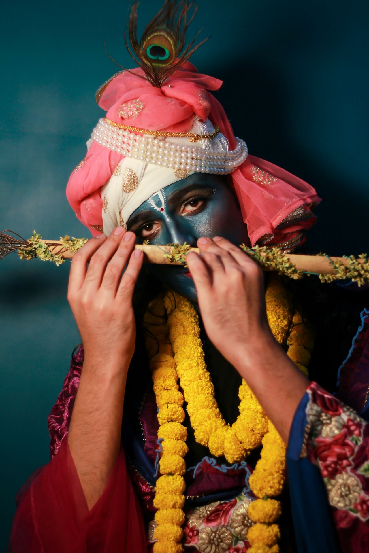 a man with a mask on holding a stick to his face